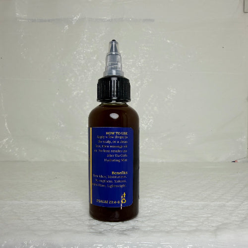 Bottle of Da Girls Oil with a blue label on a textured white surface