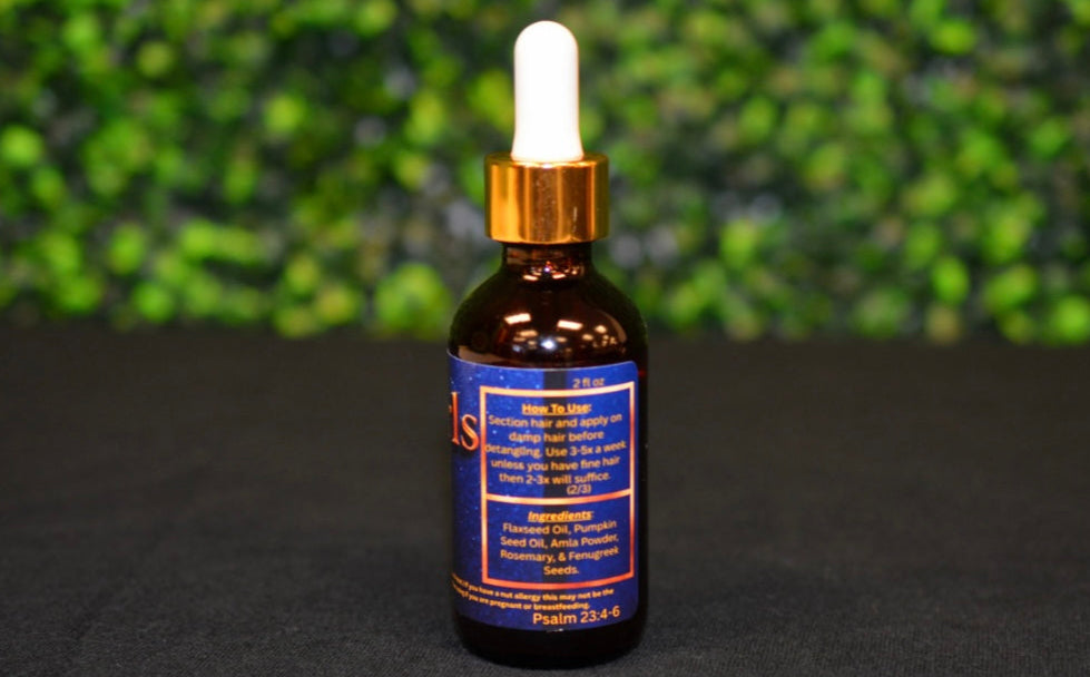 Bottle of tincture with dropper on a black surface with greenery in the background