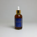 Bottle of Da Girls serum with dropper on a textured white surface