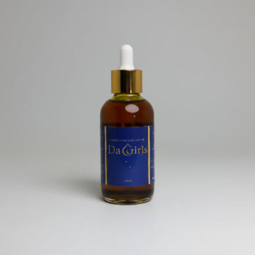 Bottle of Da Girls serum with dropper on a textured white surface